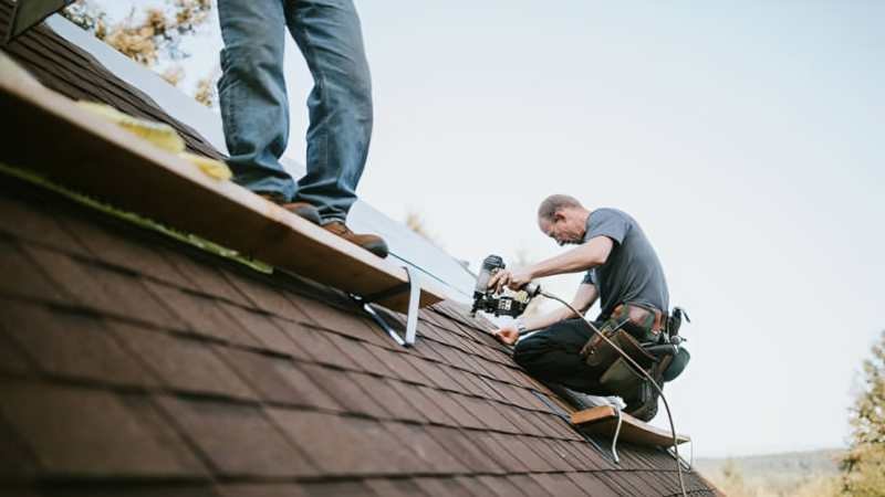 Roofing contractors serving CT inspecting a residential roof