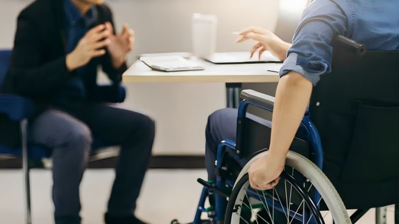 Wheelchair user discussing support and care needs with an advisor